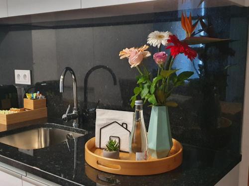 um balcão de cozinha com um vaso de flores e um lavatório em PIMENTA FOUR HOUSE em Amarante