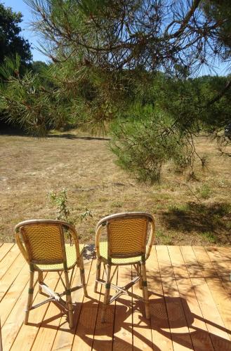 2 chaises assises au-dessus d'une terrasse en bois dans l'établissement La pause tiny, à Ploërmel