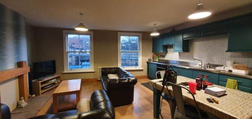 a kitchen and living room with a couch and a table at The Pebbles in Whitby