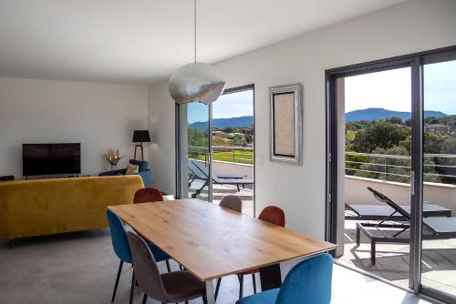 une salle à manger avec une table et des chaises en bois dans l'établissement Domaine d'Arca Porto Vecchio - Hugo 13 - Toit Terrasse - Haut standing, à Porto-Vecchio