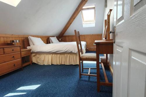 a bedroom with a bed and a desk and a chair at Stylish, comfortable apartment with balcony in Plymouth