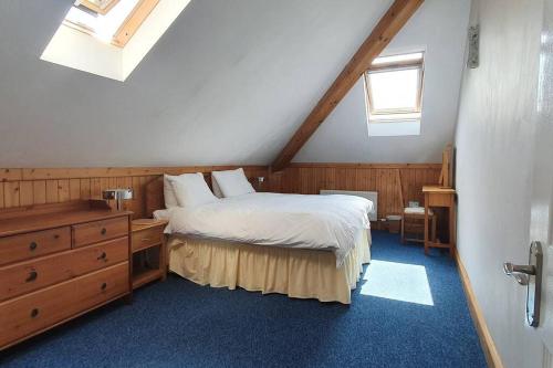 1 dormitorio con 1 cama, vestidor y ventanas en Stylish, comfortable apartment with balcony, en Plymouth