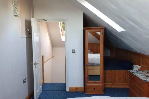 an attic room with a mirror and a bedroom at Stylish, comfortable apartment with balcony in Plymouth