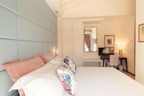 a bedroom with a white bed and a desk at Villa Francesca Relais in Gradara