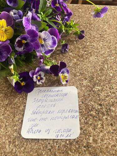 a note next to purple flowers next to a bouquet of flowers at Har-Mar Hotel in Goris