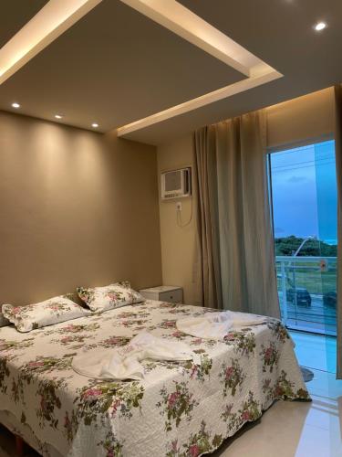 um quarto com uma cama e uma grande janela em Apartamento Praia do Forte, Cabo Frio, Frente mar em Cabo Frio