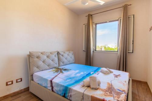 a small bedroom with a bed and a window at Casa vacanza Il Melograno in Santa Maria Del Focallo