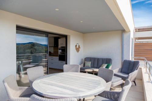 un patio avec une table et des chaises sur un balcon dans l'établissement Domaine d'Arca Porto Vecchio - Piscine - Tennis - 6 personnes 