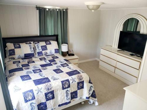 a bedroom with a bed and a flat screen tv at Bright and airy beach house. in Myrtle Beach