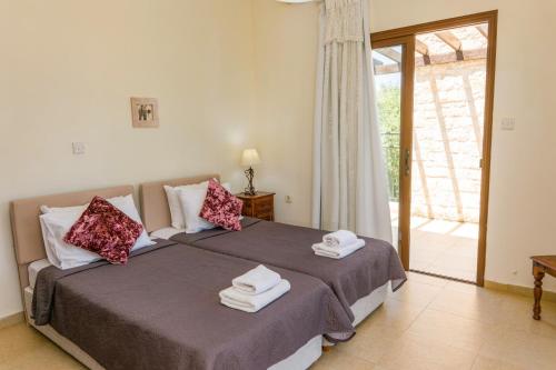 a bedroom with a bed with towels on it at Villa Lena by Villa Plus in Prodhromi