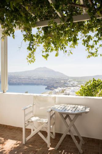 a table and a chair on a balcony with a view at Villa Galinia in Akrotiri