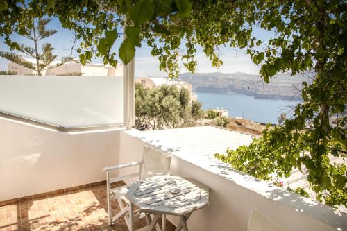 a white balcony with a table and a chair at Villa Galinia in Akrotiri