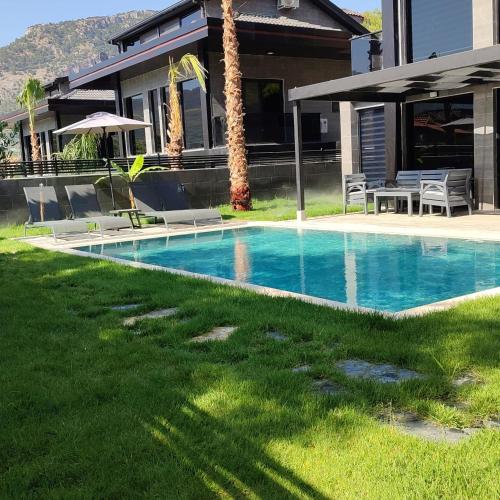 a swimming pool in a yard next to a house at Diamond Port Gocek in Göcek