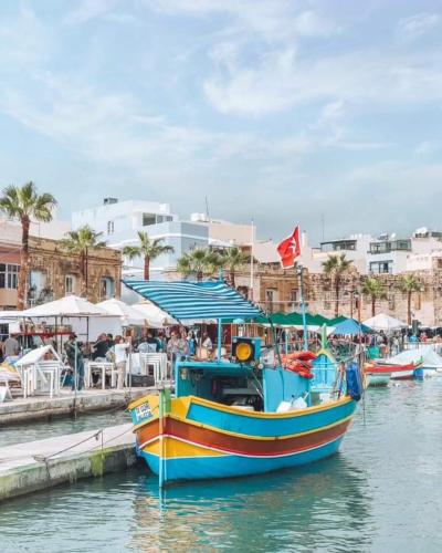 a colorful boat is docked at a dock at Casal Annunzia Boutique Accomodation in Tarxien