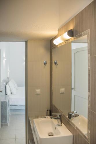 a bathroom with a sink and a mirror and a bed at Villa Galinia in Akrotiri