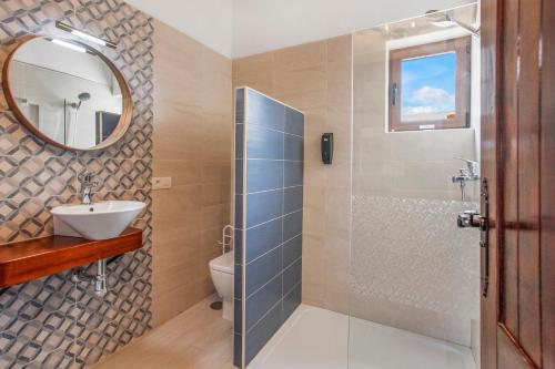 uma casa de banho com um chuveiro, um lavatório e um espelho. em Casa Flora em Villaverde