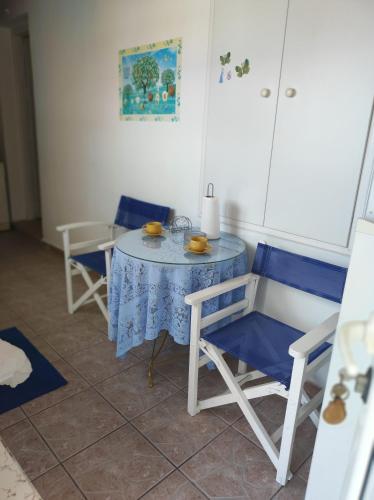 a table with two chairs and a table with a blue table cloth at Roubinis House in Ermioni