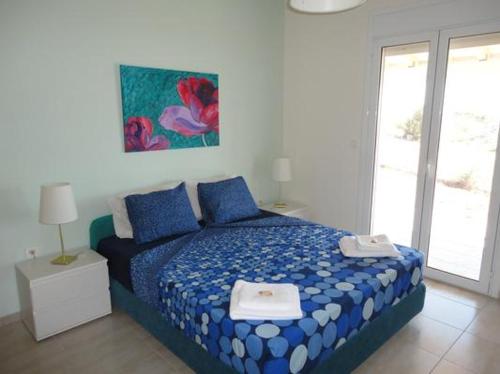 een slaapkamer met een blauw bed met blauwe kussens bij Panorama View Evia GREECE in Kamarítsa