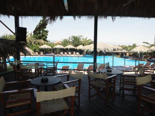 een restaurant met tafels en stoelen en een zwembad bij Panorama View Evia GREECE in Kamarítsa