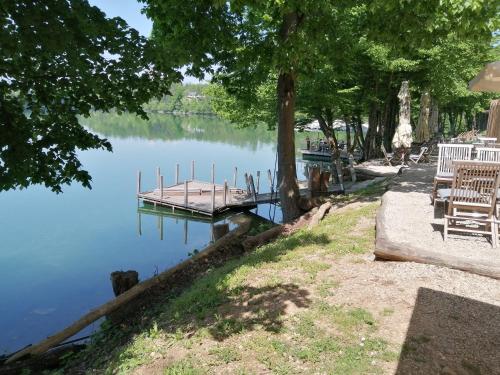 a dock on a lake with a table and chairs at Glamping with a view in Smlednik