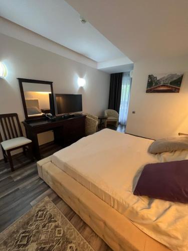 a bedroom with a large bed and a desk at Alpin Resort Apartments Deluxe 2406 in Poiana Brasov