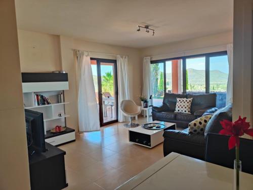 a living room with a couch and a tv at Golf & Spa resort with new big luxery appartement in Lorca