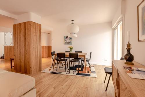 un salon et une salle à manger avec une table et des chaises dans l'établissement La Perrinière appartement face mer, à Royan