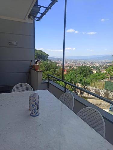 a table with chairs and a cup on a balcony at La Terrazza Quisisana Sorrento Coast in Castellammare di Stabia
