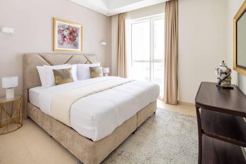 a bedroom with a large white bed and a window at Frank Porter - Mon Reve in Dubai
