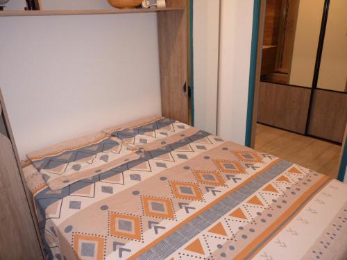 Ce lit se trouve dans une petite chambre dotée d'un couvre-lit. dans l'établissement Sol-y-Days Murènes, Appartement moderne rive droite proche plages et centre, au Grau-du-Roi