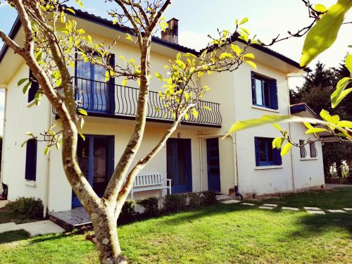 a house with a tree in front of it at Le Logis de la Ferme aux Cerfs in Le Houga