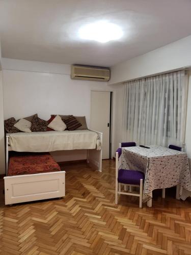 a bedroom with two beds and a table and a chair at Amusing Apartment Recoleta in Buenos Aires