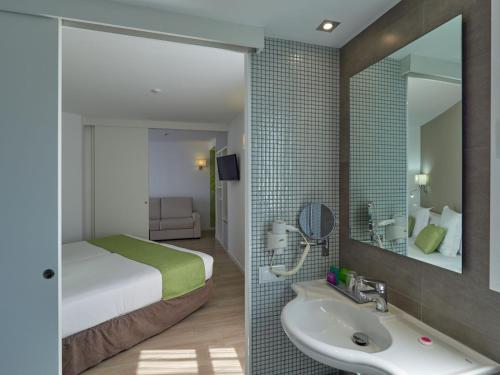 um quarto de hotel com uma cama e um lavatório em BQ Amfora Beach - Adults Only em Can Pastilla