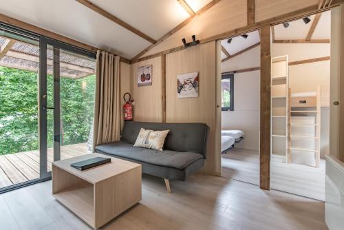 een woonkamer met een bank en een bed bij Les Lodges Chalets by Le Marintan in Saint-Michel-de-Maurienne