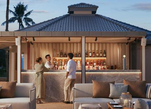 a man and a woman standing at a bar at Dusit Thani Hua Hin in Cha Am
