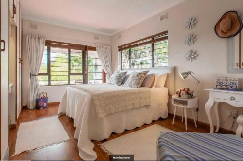 um quarto com uma cama e duas janelas em Ariel's Rest Self-catering - 4 Bedroom Luxury Home em Pennington