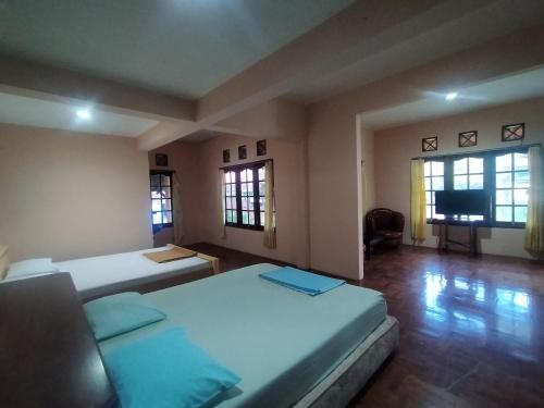 a room with two beds and a flat screen tv at Villa Batu Tua Puncak Mitra RedDoorz in Bogor