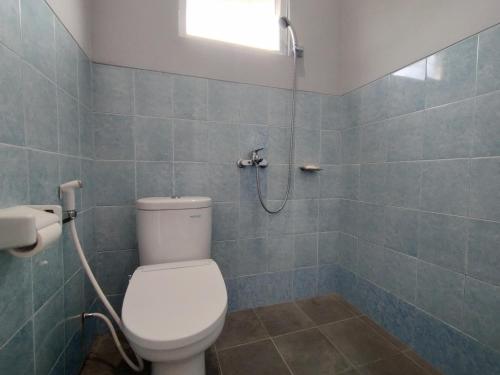 a bathroom with a toilet and a shower at Villa Batu Tua Puncak Mitra RedDoorz in Bogor
