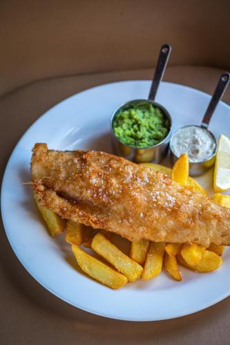 a white plate with fish and french fries and sauce at The Pier Hotel in Harwich