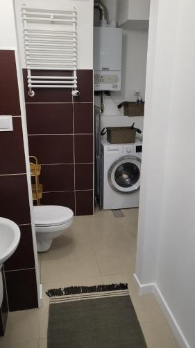 a bathroom with a toilet and a washing machine at Apartament Mochnackiego in Olsztyn