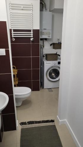 Un baño con inodoro y lavadora. en Apartament Mochnackiego, en Olsztyn