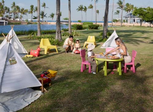 a group of people sitting around a table with tents at Dusit Thani Hua Hin in Cha Am