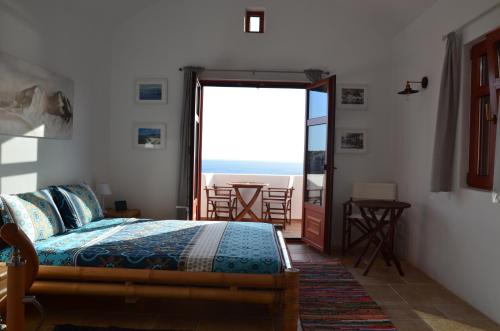 Venus Hill Guest House في Lefkogeia: غرفة نوم مع سرير وإطلالة على المحيط