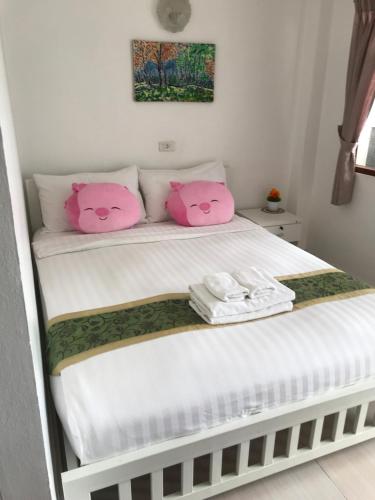 a bed with two pink hello kitty pillows on it at Tong Mee House Hua Hin in Hua Hin