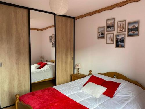 - une chambre avec un lit rouge et blanc et un miroir dans l'établissement Appt 50m2, 4 personnes, ménage, draps et serviettes inclus, à Gérardmer