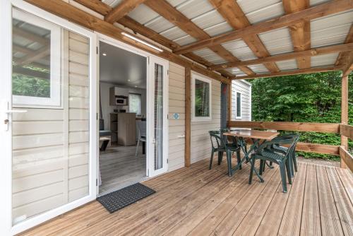 - une terrasse couverte avec une table et des chaises dans l'établissement Les Mobil-homes By Le Marintan, à Saint-Michel-de-Maurienne