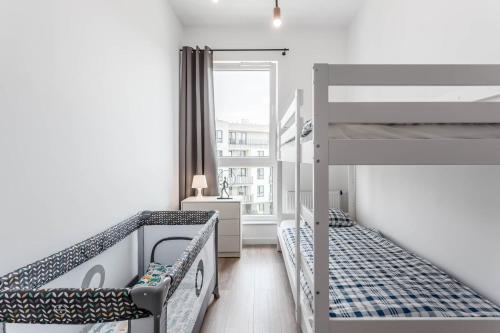 a bedroom with two bunk beds and a window at Chill Apartments Ursynów Premium in Warsaw
