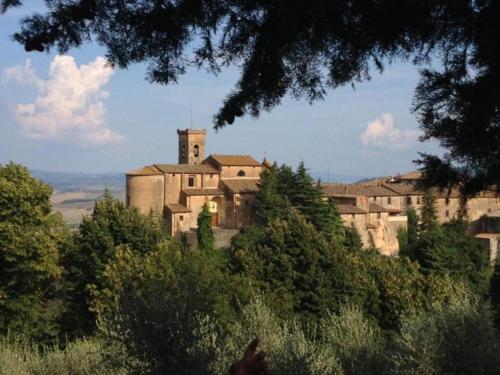 an old building on top of a hill with trees at LA CASA DI CHIANNI La Pieve in Chianni
