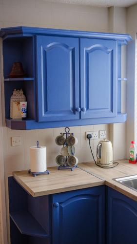 a kitchen with blue cabinets and a counter top at Horizon View Portstewart Tourist Board approved in Portstewart