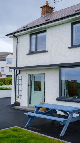 a blue picnic table in front of a house at Horizon View Portstewart Tourist Board approved in Portstewart